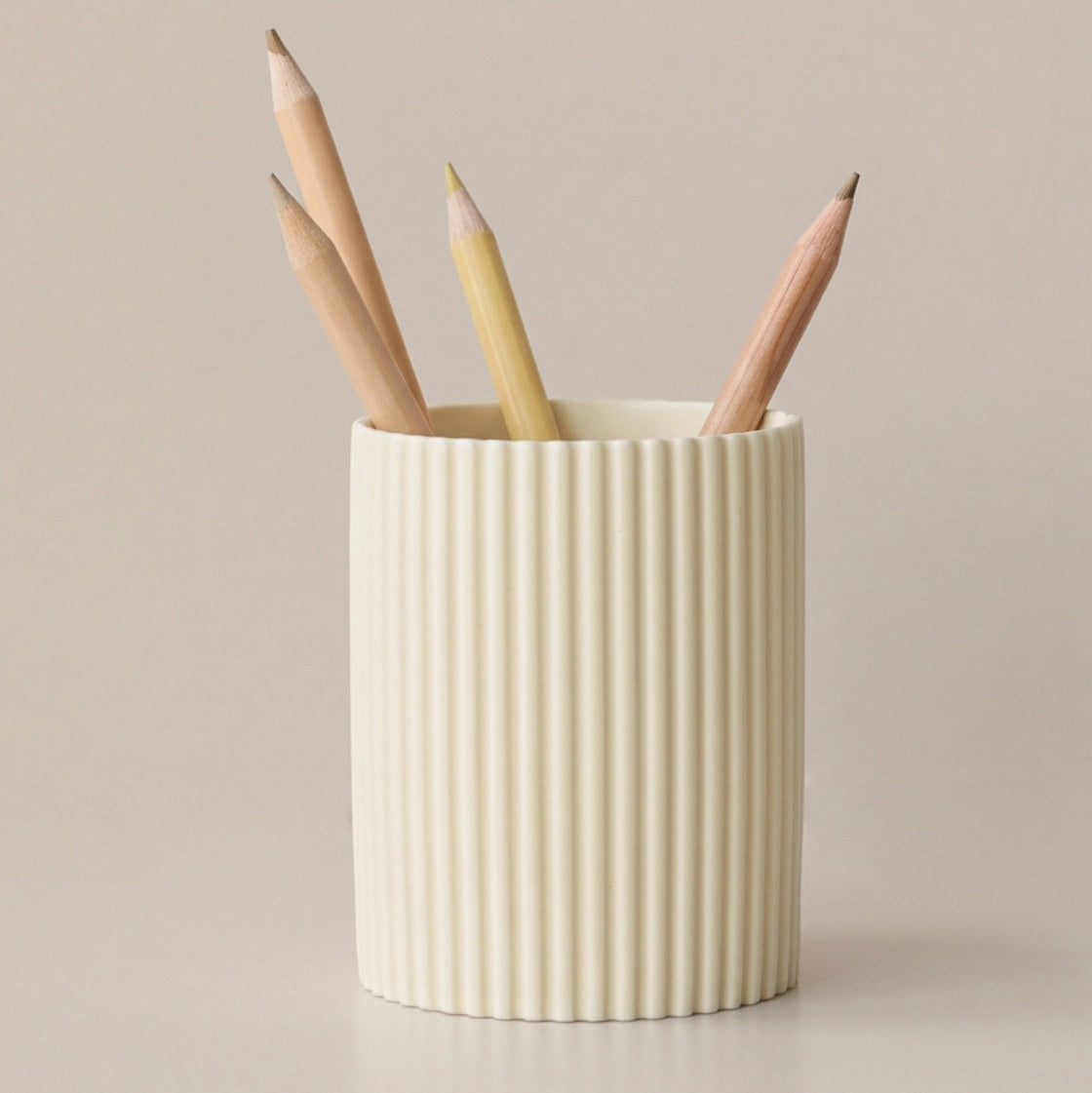 Cream cylindrical pen holder with fine vertical ribbing
